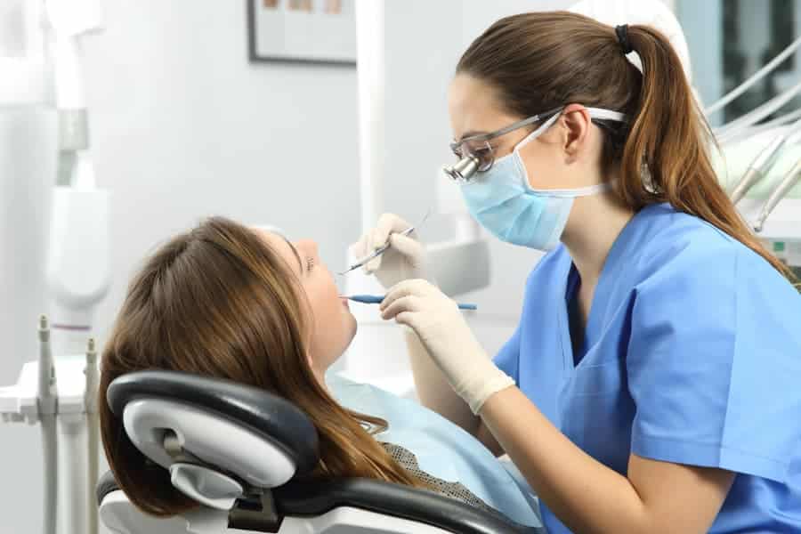 Dental Hygienist Performs Exam